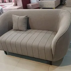 A custom-made two-seater sofa with channel-tufted backrest and a curved design, perfect for a cozy seating nook.