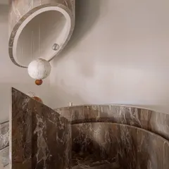 A view from the top of the staircase, looking down at the floating spheres and the intricate marble work.
