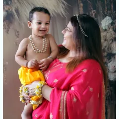 A joyful moment between a mother and her son during a Janmashtami themed shoot. The baby's happy smile makes this photo truly precious.