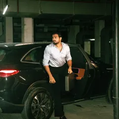 An on-location shoot with a strong narrative feel. The moody lighting of the underground parking lot and the dynamic pose create a cinematic moment, perfect for a men's fashion editorial or a brand campaign that tells a story.