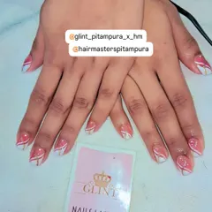 This geometric design features a soft pink base with crisp white and gold lines creating a modern, abstract pattern. It's a great example of how we can use simple lines to create a sophisticated and unique nail art look.