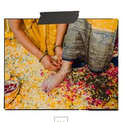 A detail shot of an anklet being tied on the bride's foot amidst a bed of flower petals during the Haldi rituals.