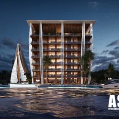 The Koh Lanta project at night. The lighting design highlights the building's unique form, which is inspired by the coastal landscape. The property is designed to feel like a relaxed, contemporary resort.