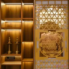 A close-up of a custom pooja unit door featuring an intricate 'Shri Yantra' laser-cut jaali design. The backlighting creates a beautiful, divine glow.