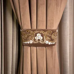 A handcrafted tie belt, featuring intricate gold and white floral embroidery on a soft brown velvet. This is not just an accessory, but a statement piece that reflects your unique style.