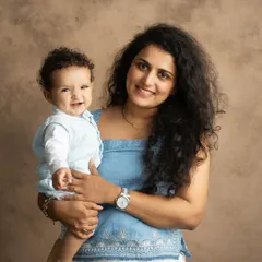 A beautiful portrait of a mother and her smiling baby looking at the camera. Their connection is so clear and heartwarming.