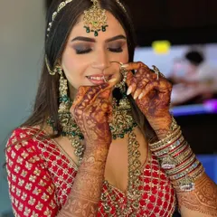 A candid moment of my bride adjusting her nose ring. Her look features a classic smokey eye and neutral lips, perfectly complementing her traditional red and green bridal attire.