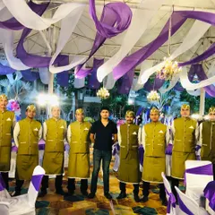The full team, including the event supervisor, ready for service. We work as a cohesive unit to manage every aspect of the catering, from cooking to serving and clean-up.