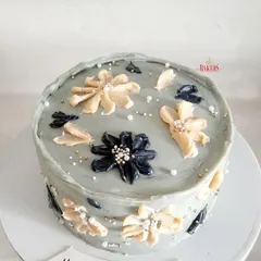 A gorgeous floral birthday cake for a young lady celebrating her 18th birthday. The rustic, hand-painted buttercream flowers in black, white, and grey create a sophisticated and artistic look.