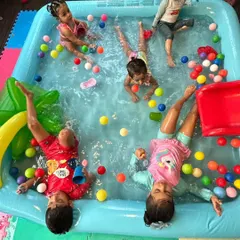 Nothing beats the fun of a pool day! Here, a group of friends are splashing and playing in an inflatable pool filled with colorful balls. I make sure to include water play activities for a full sensory experience.