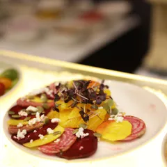 A vibrant beetroot and citrus salad, garnished with feta cheese and pumpkin seeds. This colourful and healthy dish is a beautiful addition to any buffet spread, offering a refreshing counterpoint to richer dishes.