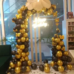 A chic black and gold balloon arch, perfect for an elegant birthday celebration in a cafe or restaurant. I added gold butterfly accents and a "Happy Birthday" neon sign to complete this sophisticated look.