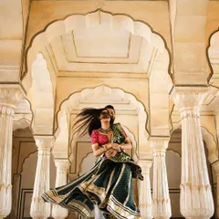 A joyful moment captured as the groom twirls his bride in the arched corridors of a Jaipur palace. This image showcases our expertise in destination pre-wedding shoots, blending movement and magnificent architecture.