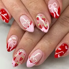 Getting your nails ready for a special date. This lovely Valentine's design features hand-painted strawberries, delicate bows, and heart patterns on a pink and red base.