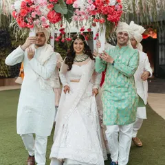 The bride arrives! Carried in under a beautiful floral canopy by her brothers and friends, her smile is radiant. This is a bridal entry filled with love, support, and happiness.