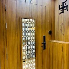 This is a finished safety door project in a rich wood laminate. It features a geometric jaali panel for ventilation and security, a digital lock, and a backlit ceiling panel.