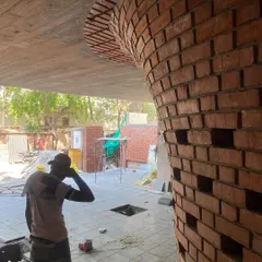A close-up of the curved brickwork on the Waterfall house. This image shows the craftsmanship involved in laying each brick to create a smooth, flowing surface that merges into the concrete ceiling above.