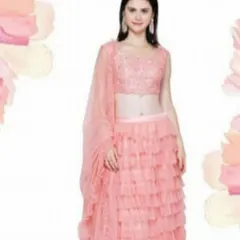 Embrace a playful and trendy style with this peach lehenga featuring a multi-layered ruffled skirt. Paired with a beautifully embroidered sleeveless blouse and a sheer dupatta, this outfit is a youthful and fashionable choice for daytime weddings or festive events.
