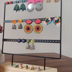 A display of the variety of earrings I create. You can see everything from large mirror work chandbalis and colorful jhumkis to hand-painted studs, all handmade by me.