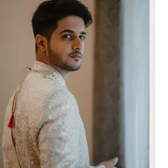 A classic groom portrait by the window, capturing his thoughtful expression as he looks back.