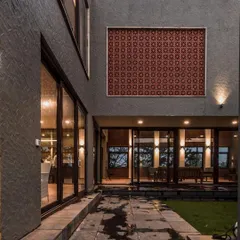 We use a combination of materials to create texture and interest on our facades. Here, a traditional red jali panel is set into a modern grey textured wall, creating a dynamic contrast of color and form.
