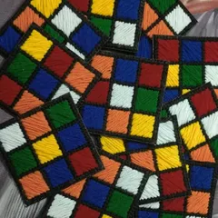 A pile of our handmade Rubik's Cube coasters. This retro design is a fun conversation starter and a great gift for anyone who loves puzzles and 80s nostalgia.