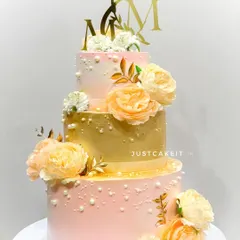 This elegant three-tier wedding cake features a beautiful blend of peach and gold tones, adorned with delicate sugar flowers. It’s a perfect example of how I create stunning, eggless centerpieces for your most special day, built sturdy enough to travel anywhere in Mumbai.