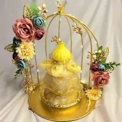 A creative way to present smaller gifts in a trousseau. This golden birdcage platter, decorated with flowers and fairy lights, turns a simple gift into a stunning decorative piece.