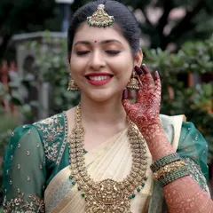 A bride’s smile is my greatest reward. This bride chose an elegant off-white Kanjeevaram silk saree with a rich emerald green border and a matching embroidered puff-sleeve blouse, proving that you don't need red to be a classic bride.
