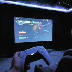 This image showcases the PS5 interface on a wall-to-wall projector screen. The dark room, combined with the starry ceiling and comfortable seating, makes for hours of comfortable, epic gaming.