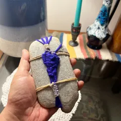 The back of the wrapped pebble reveals the knotting and finishing techniques used to secure the weave. Every part of the object is considered, making the final piece a complete little work of art from all angles.