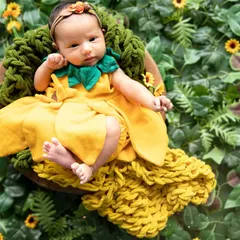 Capturing the delicate innocence of a newborn is my greatest passion. In this newborn portrait, I used soft, natural elements like this sunflower-themed wrap and lush greenery to create a peaceful, organic setting for this one-month-old darling.