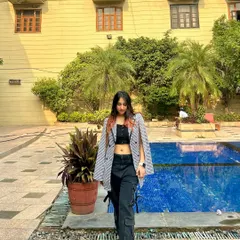 A chic poolside look with a blazer worn as a cape over a crop top and cargo pants. This shows my ability to create fashion-forward, layered looks.