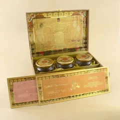 This opulent invitation box features intricate gold foil work on the inside lid and a velvet-lined interior. It holds multiple inserts and three matching gift jars, making it a truly luxurious announcement.