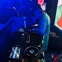 Focused on the decks during a wedding party. I make sure the sound is perfect and the playlist flows seamlessly to keep the celebration going.