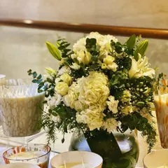 A classic bouquet is always a good choice. This arrangement features a full bunch of white hydrangeas, elegant white lilies, and soft roses, accented with fresh eucalyptus leaves and baby's breath in a simple glass vase.