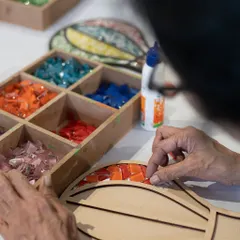 Art is for everyone, and I love seeing different generations create together. Here, a grandmother is enjoying the mindful process of making a mosaic. It’s a beautiful way to bond and make memories.
