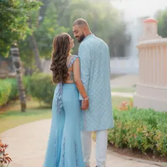 A candid shot from behind as a couple walks through a garden path during their Haldi celebration. This photo highlights the beautiful details of the bride's outfit and captures a quiet, in-between moment.