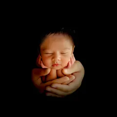 There is nothing more precious than a newborn. I created this artistic, low-key portrait to highlight the baby's delicate features, held safely in their parent's hands. It's a simple, powerful image that families treasure forever.