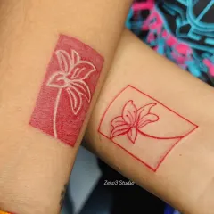 A closer look at the red ink couple tattoos. The negative space design on one arm and the line-art on the other create a perfect pair.