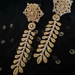 My classic leaf danglers, a favorite for their elegance and feathery feel. These 18k gold earrings feature a floral stud and a long, textured leaf design with a central line of diamonds.