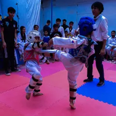 Two young competitors face off during the 1st Strike Inter-Club Tournament, demonstrating their kicking skills in a controlled match.