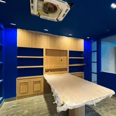 The vibrant royal blue paint being applied to the walls and ceiling, a signature element of the Weatherseal brand identity. This image captures the moment the space begins to reflect the bold design concept.