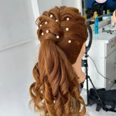 A beautiful high ponytail with curls and pearl accessories, created on a mannequin head. I teach a variety of modern and classic hairstyles in my course.