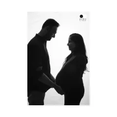 A classic black and white silhouette of an expecting couple holding hands, their profiles creating a beautiful and intimate portrait.