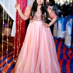 A client glowing in a peach Anarkali gown with an embroidered bodice and sheer puff sleeves. This is a perfect outfit for an evening reception or party.