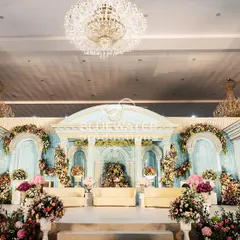 A frontal view of the 'Blue Palace' stage, highlighting the detailed architectural elements, the balance of powder blue and white, and the abundant florals that add softness and color.