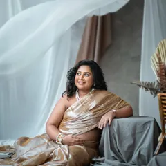 A serene and graceful pose, showcasing the beauty of the expecting mother in a shimmering golden saree.