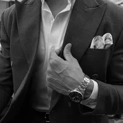 The difference is in the details. This close-up of a custom double-breasted suit highlights the sharp peak lapel, the perfect pocket square, and the way the fabric drapes. We believe true elegance is achieved through meticulous attention to every single element.