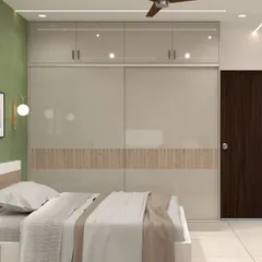 A floor-to-ceiling sliding wardrobe with high-gloss beige doors. The central fluted wood panel adds a touch of texture and warmth, complementing the room's serene green accent wall.